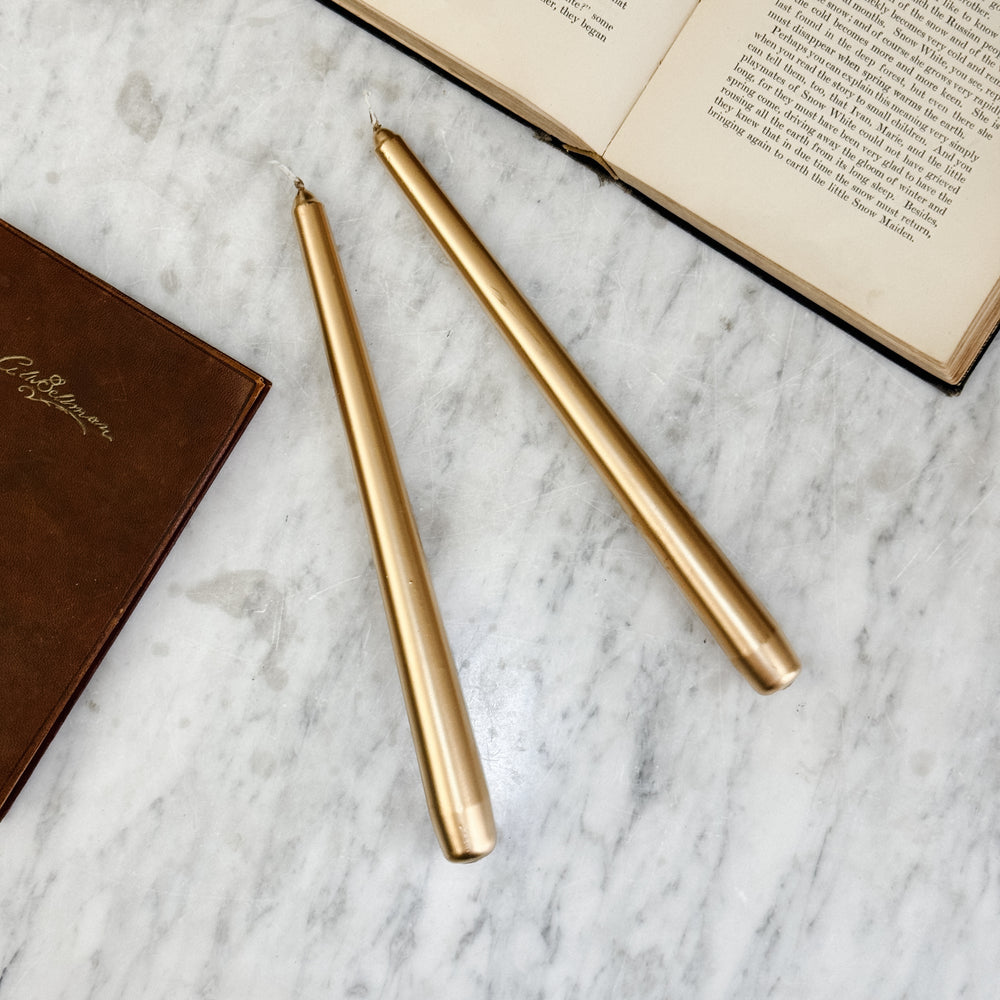 Metallic gold taper candle.