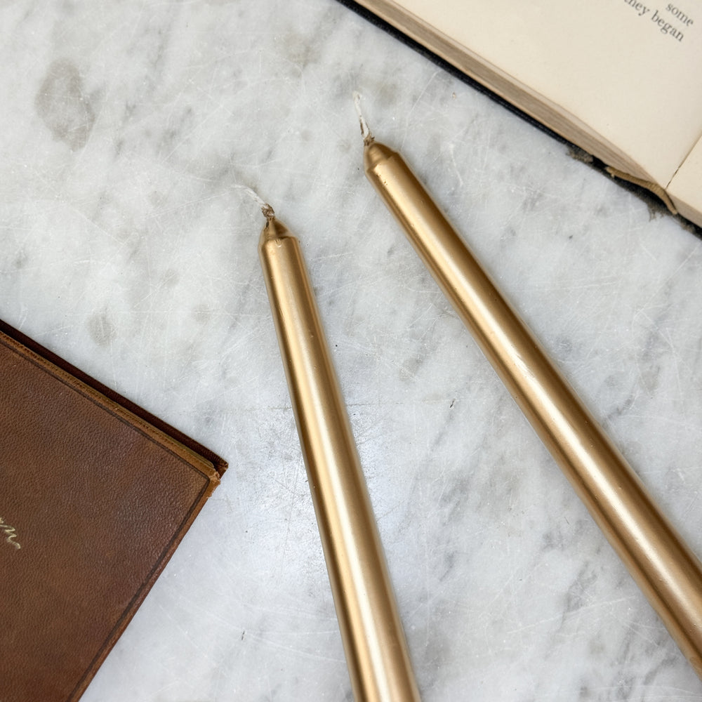 Metallic gold taper candle.