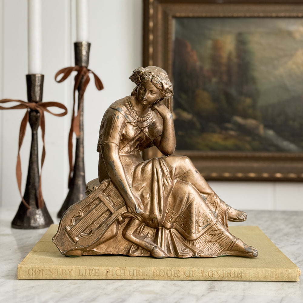 Vintage gold woman of music statue.