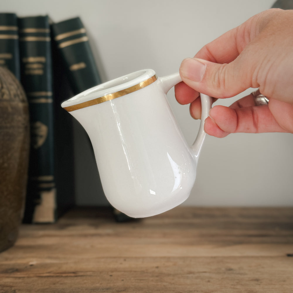 Vintage buffalo gold rim creamer.