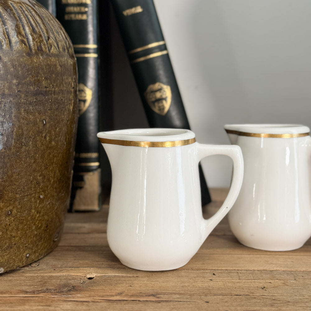 Vintage buffalo gold rim creamer.